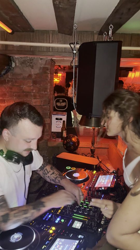 DapSoul at the mixer with a woman beside the booth